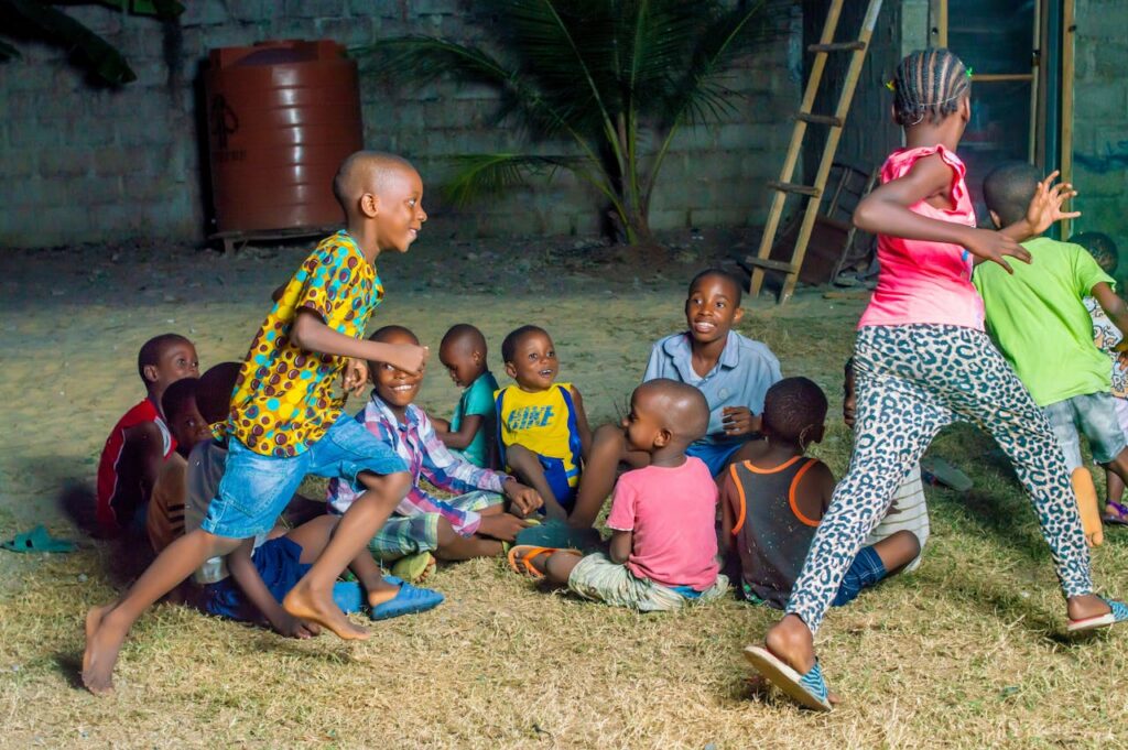 Group of African children playing joyfully in an outdoor setting, showcasing friendship and fun.