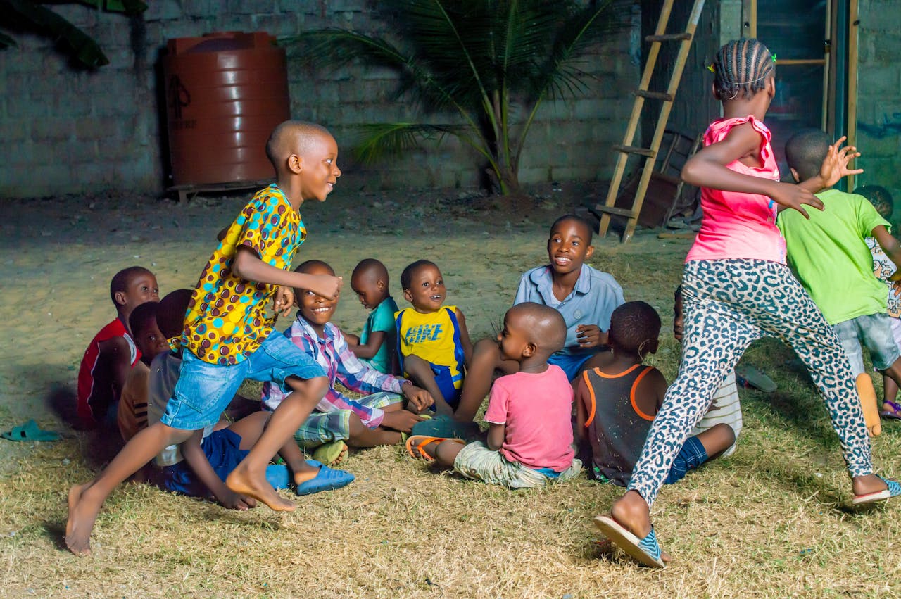 Group of African children playing joyfully in an outdoor setting, showcasing friendship and fun.