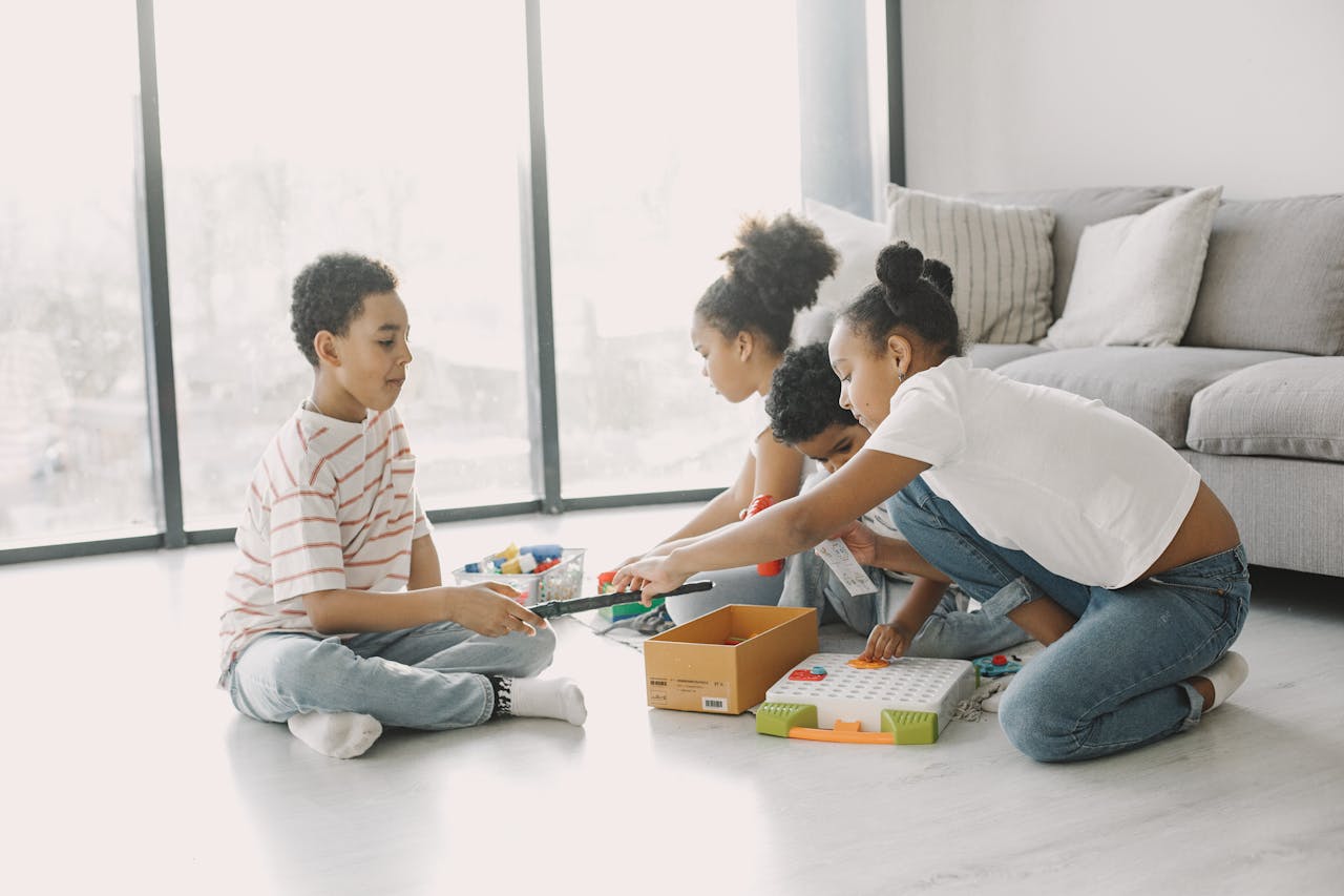 A group of children engaging in play with toys and games on a sunny day indoors.